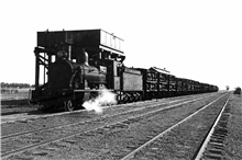 A Steam locomotive taking water from the tower before continuing across NW NSW.